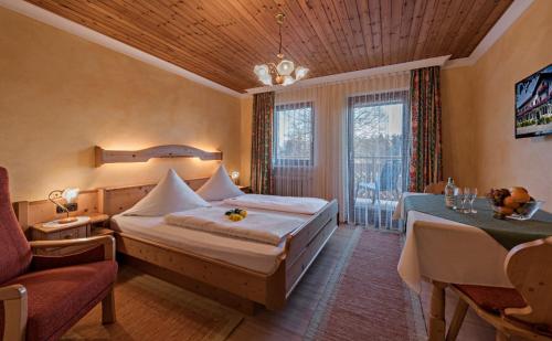 um quarto com uma cama, uma mesa e uma janela em Landgasthof Zum Sägwirt em Eggstätt