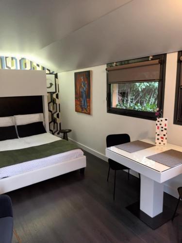 a bedroom with two beds and a table and a window at Chambre d'Hotes "Riad des Baudières" in Bourg-en-Bresse