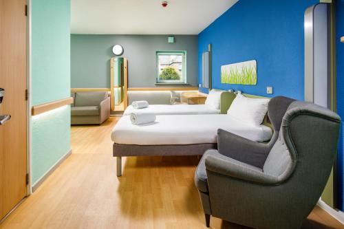 a hotel room with a bed and a chair at ibis budget Sheffield Arena in Sheffield