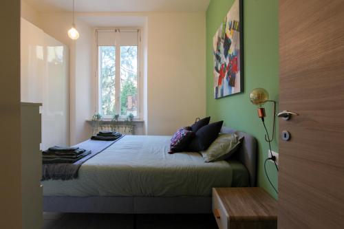 a bedroom with a bed with pillows and a window at Modern apartment close to shopping district in Milan