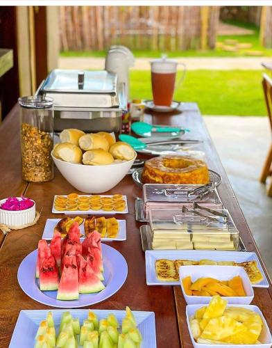 ein Tisch mit einer Reihe von verschiedenen Arten von Lebensmitteln in der Unterkunft Chalés Milagres Beach in São Miguel dos Milagres