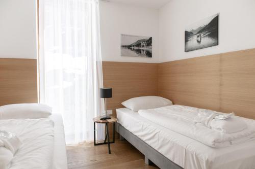 a bedroom with two beds and a window at Residence Bellevue - incl Summercard in Zell am See