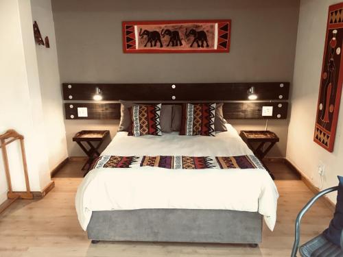 a bedroom with a large bed with a large headboard at Two Falls View in Sabie
