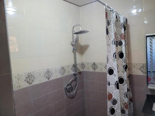 a shower with a shower curtain in a bathroom at Jnane Ville Verte in Casablanca