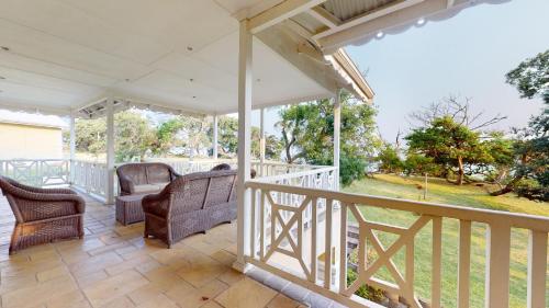 a porch with chairs and tables on a deck at Khumbula at Caribbean Estates in Port Edward