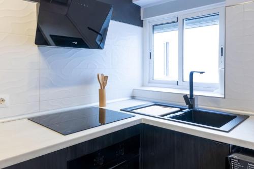 una cucina con lavandino e finestra di Apartamento completo a 5 minutos estación tren. a Cordoba