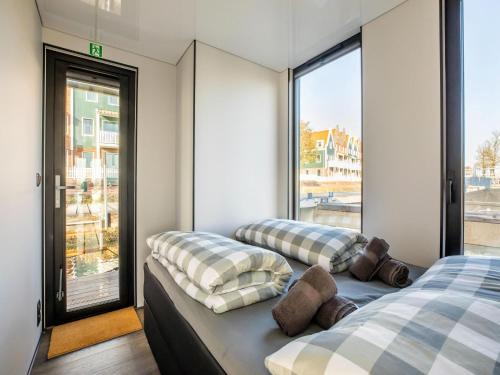 two beds in a room with a window at Inviting houseboat in Volendam with shared pool in Volendam