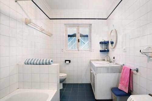 a white bathroom with a sink and a toilet at El Mirlito in Roche