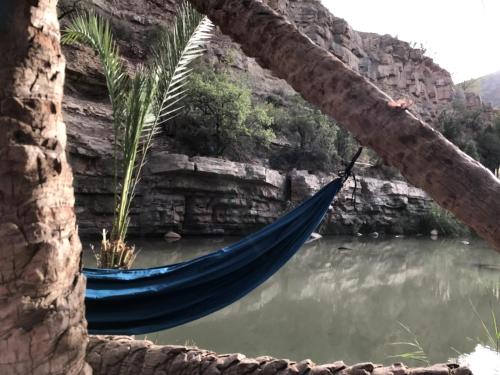 a hammock hanging in front of a body of water at Wavy Days in Tamraght Ouzdar