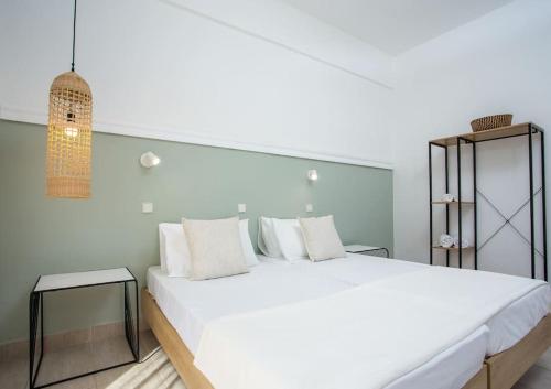 a white bedroom with a large white bed with white pillows at Rosie's Studio 3 in Faliraki