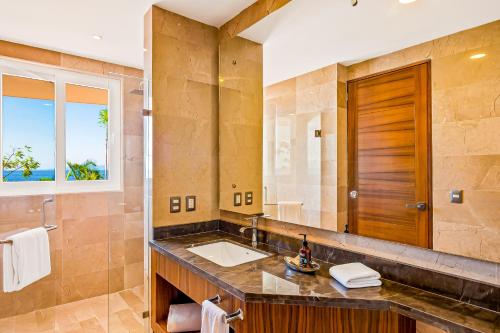 a bathroom with a sink and a large mirror at Blue Horizon 103 in Puerto Vallarta