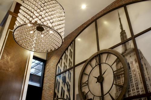 a large chandelier and a large clock in a room at Archer Hotel New York in New York