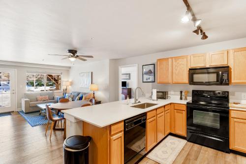 a kitchen with wooden cabinets and a living room at First Tracks 4105 in Steamboat Springs