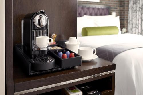 a black coffee maker on a table next to a bed at Archer Hotel New York in New York