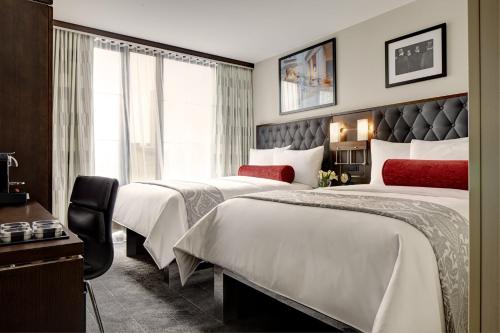 een hotelkamer met 2 bedden en een raam bij Archer Hotel New York in New York