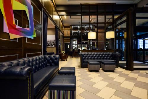 a waiting room with leather couches and a bar at Archer Hotel New York in New York