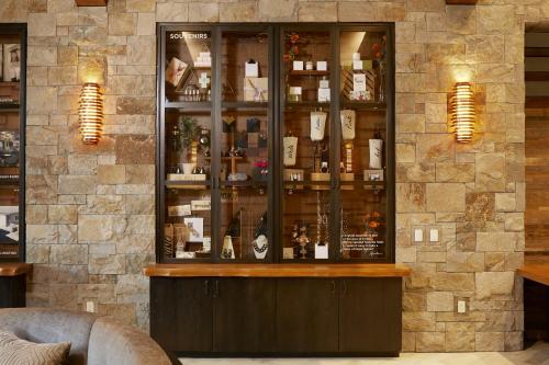 a bar with a display case in a room at Archer Hotel Napa in Napa