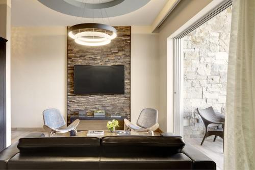 a living room with a couch and a tv on a brick wall at Archer Hotel Napa in Napa