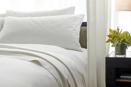 a white bed with white sheets and a window at Archer Hotel Napa in Napa