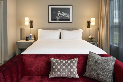 um quarto com uma cama grande e um sofá vermelho em Archer Hotel Seattle/Redmond em Redmond