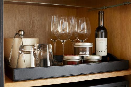 a shelf with wine glasses and a bottle of wine at Archer Hotel Napa in Napa