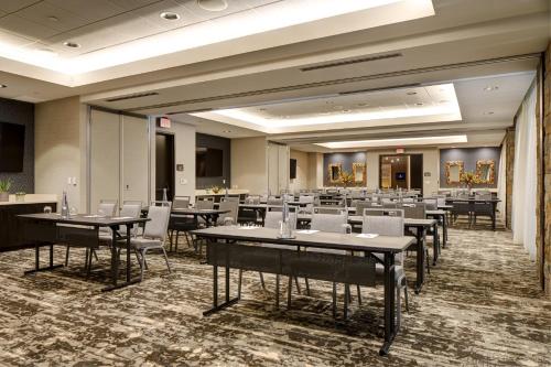 a banquet hall with tables and white chairs at Archer Hotel Napa in Napa