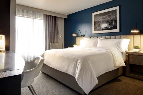 a bedroom with a large white bed and a desk at Archer Hotel Florham Park in Florham Park