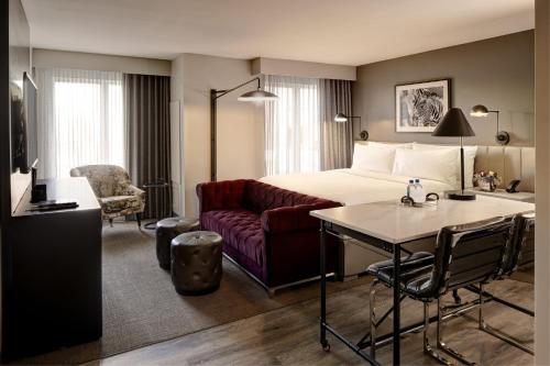 a hotel room with a bed and a couch at Archer Hotel Boston/Burlington in Burlington