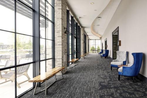 a hallway with chairs and tables and windows at Archer Hotel Florham Park in Florham Park