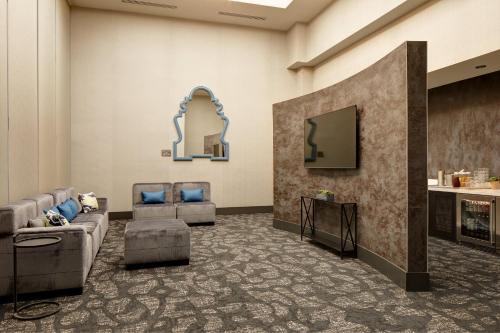 a living room with couches and a tv and a mirror at Archer Hotel Florham Park in Florham Park