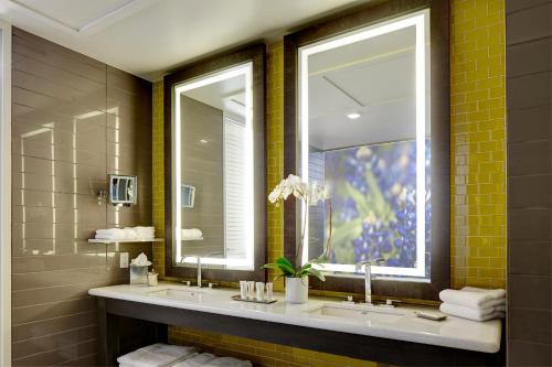 uma casa de banho com 2 lavatórios e um espelho grande em Archer Hotel Austin em Austin