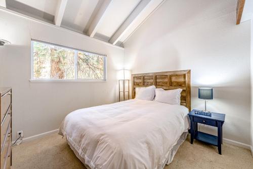 a bedroom with a large white bed and a window at Take Me to Tahoe in Incline Village