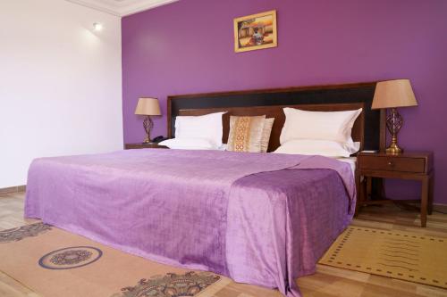 - une chambre violette avec un lit et une couverture violette dans l'établissement Le Feto 2, à Dakar