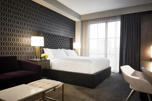 a hotel room with a large bed and a couch at Archer Hotel Tysons in Tysons Corner