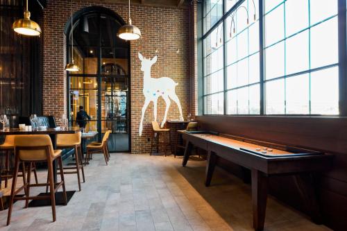 a restaurant with a table and a deer on the wall at Archer Hotel Tysons in Tysons Corner
