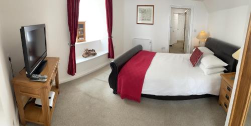 a bedroom with a bed and a television in it at Sawyers Bed and Breakfast in Looe