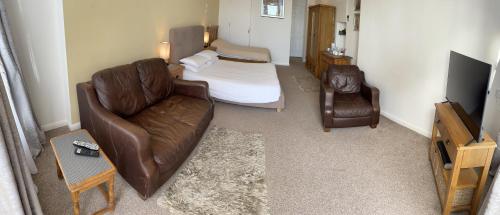 a living room with a couch and a bed at Sawyers Bed and Breakfast in Looe