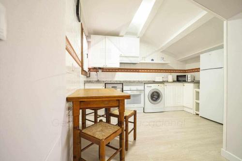 a kitchen with a table and chairs in a room at El Pico, Apartamento in Ribadesella