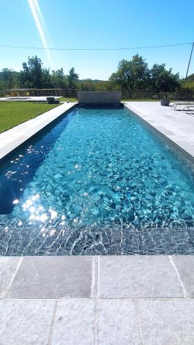 a swimming pool with blue water in a yard at Cascina Formighezzo in Arquata Scrivia