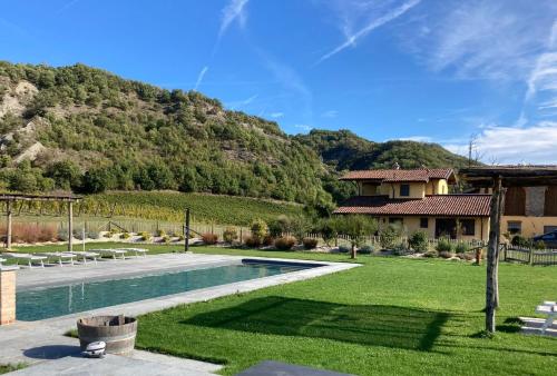 a house with a swimming pool and a mountain at Cascina Formighezzo in Arquata Scrivia