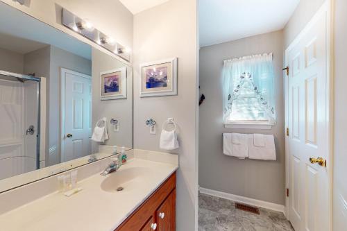 un baño con lavabo y espejo en Bethany Bay - 37278 Fox Dr, en Ocean View