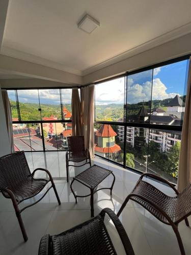 a room with chairs and a balcony with a view at Apartamento na Avenida próximo das Termas in Piratuba