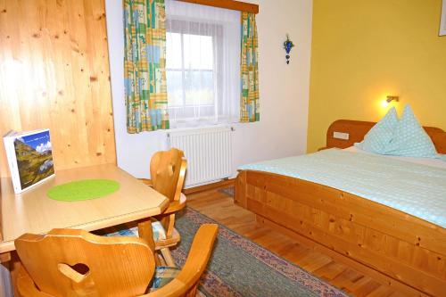 a bedroom with a bed and a desk and a table at Hiaslahof in Mariapfarr
