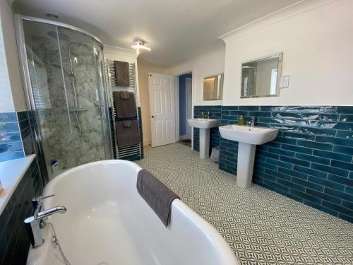 a bathroom with a tub and a sink at The Farmhouse in Pontefract