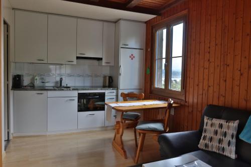 a kitchen with white cabinets and a table with chairs at Hof Oberprehl in Murten