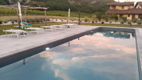 a swimming pool with tables and chairs in a yard at Cascina Formighezzo in Arquata Scrivia