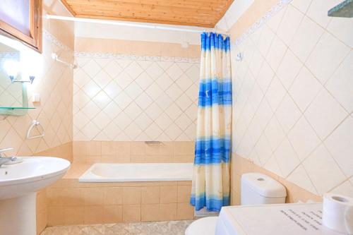 a bathroom with a tub and a toilet and a sink at Old Stone House in Nisaki