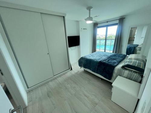 um quarto com uma cama e uma porta de vidro deslizante em Nascer do sol 102 em Arraial do Cabo