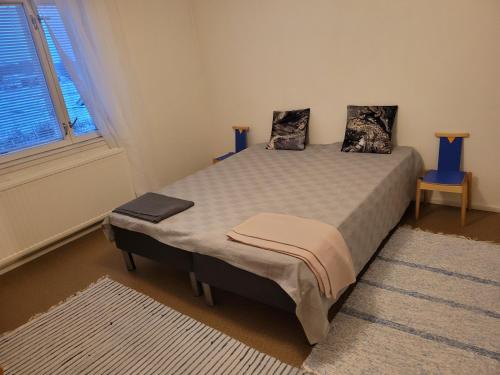 ein Schlafzimmer mit einem Bett mit zwei Kissen darauf in der Unterkunft Kattilakosken vanha Pappila in Kärsämäki