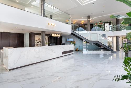 a lobby with a staircase and marble flooring at Occidental Roca Negra - Adults Only in Agaete